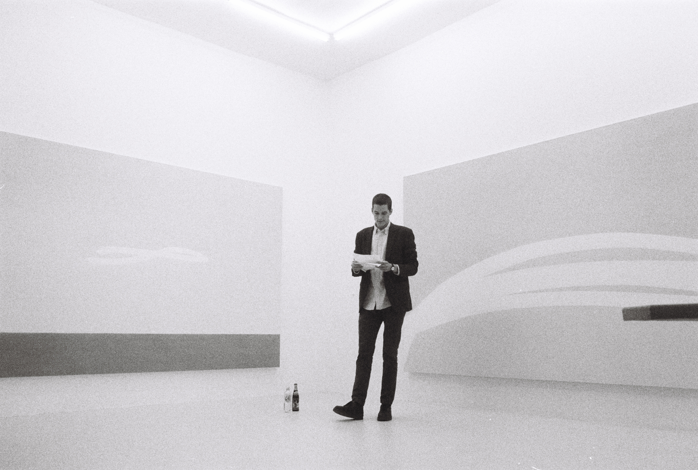 Image of Keith J. Varadi reading poetry in front of artwork by Priscilla Tea, image by Sarah Rosengarten.